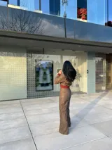 Pantalón marrón de cuero sintético con bolsillos laterales y corte recto.