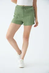 Short negro de poliéster con cintura elástica, cordón ajustable y bolsillos laterales.