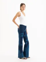 Jeans oxford de tiro medio-bajo, confeccionados en mezcla de algodón y elastano. Presentan un diseño ajustado hasta la rodilla y terminación acampanada, con un patrón gráfico de grabado láser cyanotype en tonos azules sobre base oscura.