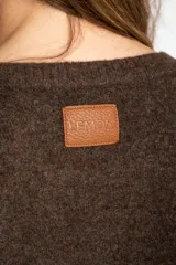 Sweater de punto con diseño color block en tonos beige, marrón y bordó, de cuello redondo y manga larga con puños acanalados en contraste.