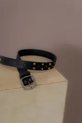 Cinturón negro de cuero vacuno con apliques de piedras y remaches dorados y plateados. Hebilla antigua con diseño floral.