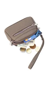 Monedero compacto de símil cuero color beige, con doble compartimento principal con cierre y un bolsillo frontal con cierre. Incluye una correa de mano lateral.