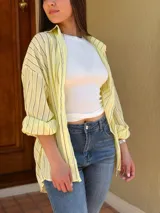 Camisa oversize a rayas de manga larga, con cuello camisero y cierre frontal de botones.