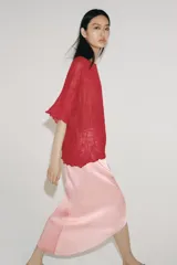 Top rojo de punto con textura efecto arrugado, cuello redondo y mangas cortas holgadas.