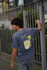 Remera de algodón 100% peinado color negro con efecto gastado, de corte recto y manga corta. Presenta un estampado gráfico en la espalda con diseño pixelado de un vaso con limonada, rodajas de limón, hojas de menta y la inscripción "summer flavor".