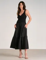 Vestido maxi combinado negro de la marca Elan, con torso de punto acanalado con escote en V pronunciado y breteles anchos. Cuenta con corte a la cintura y falda larga fluida con volumen, bolsillos laterales y volante fruncido en el ruedo.
