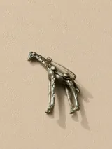 Pin metálico dorado con diseño de jirafa, ideal para personalizar prendas y accesorios.