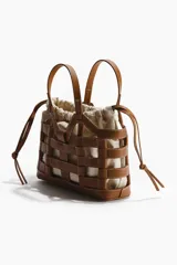 Bolso tote marrón estructurado con armazón exterior de cuero sintético entrelazado e interior de lona de lino y algodón con cordones ajustables.
