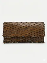 Cartera tipo sobre rígida, completamente revestida con piezas de madera tallada en forma de escamas y borde superior decorado con pequeñas cuentas de madera.