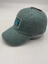 Gorra de algodón color verde con visera curva y parche bordado con motivos playeros.