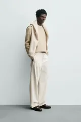 Sweater de punto color beige, de corte relajado, con cuello redondo y diseño texturizado en estructura waffle.