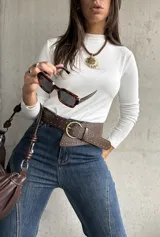 Polera de cuello alto y manga larga, confeccionada en tejido elástico de color blanco, con ajuste al cuerpo.