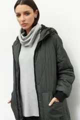 Campera de nylon larga oversized color negro, con capucha, tres bolsillos externos y uno interno. De tela capitoneada, con puños en las mangas y forro polar.