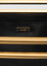 Bolso de mano tipo sobre con diseño cuadrado, confeccionado en poliéster negro. Cuenta con un asa metálica rígida en tono dorado y una cadena larga extraíble.