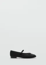 Zapato tipo bailarina color negro, con punta redonda, tira sobre el empeine con hebilla y moño decorativo.