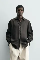 Camisa de corte relajado confeccionada en tejido fluido de lyocell. Presenta cuello solapa, manga larga con puños abotonados y cierre frontal con botones.