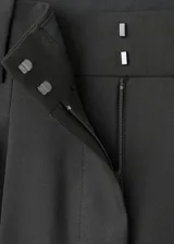 Pantalón wide leg de tiro alto color negro, con diseño largo, bolsillos laterales, detalle de pinzas y cierre oculto con botón, gancho y cremallera.