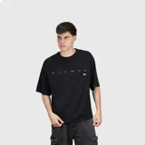 Remera negra de corte oversize, confeccionada en algodón premium con textura suave. Presenta un diseño minimalista con una pequeña estampa de texto en el pecho.