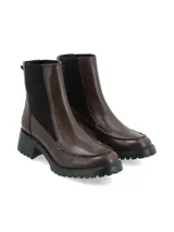 Bota tipo Chelsea de cuero color marrón, con paneles elásticos laterales en color negro, costura decorativa en la puntera y suela track dentada con taco cuadrado.