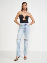 Pantalón de jean celeste con roturas en las rodillas, tiro alto y corte recto.