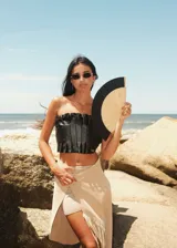 Top strapless de cuero metalizado color dorado, con diseño de tablones verticales en el frente que aportan estructura y elástico en la espalda para un ajuste cómodo.