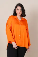 Camisa italiana de satén color naranja, de calce holgado, con manga caída y presilla para sujetar la manga. Presenta tajos a los costados y botones de nácar.