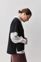 Remera de manga corta negra de algodón, con silueta relajada, cuello redondo y tajos laterales.