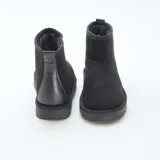 Botas cortas de estilo casual en color negro, confeccionadas en ante sintético con interior forrado y suela plana de goma.