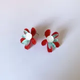 Aros tipo botón con forma de flor de pétalos turquesa y centro rosa y naranja.