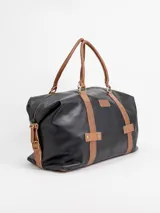 Bolso de viaje grande de cuero marrón con detalles en cuero negro, doble asa de mano y tiras decorativas verticales.