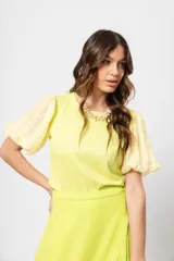 Blusa verde con cuello redondo y mangas cortas abullonadas.