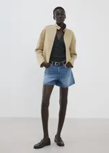 Short de denim azul de tiro medio, con diseño recto y clásico de cinco bolsillos, presillas para cinturón y cierre frontal con botón y cremallera.