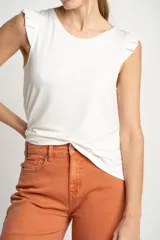 Musculosa negra de viscosa con cuello redondo y detalle de volados en los hombros. Presenta un corte holgado y fluido con un pequeño aplique metálico en el ruedo.