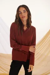 Camisa azul marino de corte clásico, con cuello camisero, mangas largas con puños abotonados y cierre frontal con botones.