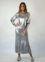 Conjunto plateado brillante de top con breteles finos y pollera larga con efecto mojado.