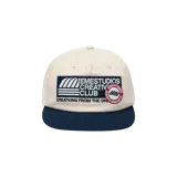 Gorra Eme Studios de color beige con visera azul marino y parches bordados frontales en contraste.