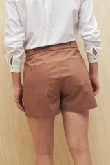 Short color marrón con cinturón, de corte recto y bolsillos delanteros y traseros.