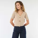 Sweater de punto en color beige, de manga corta y corte ajustado. Presenta un escote en V y cierre frontal con botones decorativos dorados en forma de concha.