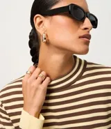 Sweater de punto de manga larga, con rayas horizontales en azul marino y blanco. Presenta cuello redondo ligeramente elevado y puños y ruedo en color blanco liso.