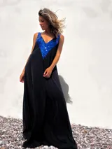 Vestido largo de corte holgado en color negro, con escote en V profundo decorado con lentejuelas azules brillantes. Presenta breteles anchos y una caída fluida.