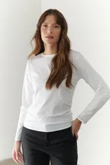 Remera blanca de manga larga con cuello redondo y costuras decorativas en contraste de color negro.