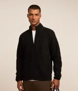 Campera deportiva negra de hombre, confeccionada en tejido fleece de poliéster, con cuello alto, cierre frontal completo y un bolsillo superior con cremallera en el pecho.