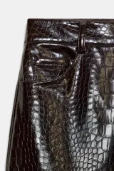 Pantalón de tiro alto con diseño de pernera recta y cinco bolsillos. Confeccionado en material con acabado efecto piel y textura de grabado animal, cuenta con cierre frontal mediante cremallera, botón interior y gancho.
