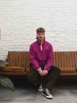 Buzo de pana color beige con cuello polo abotonado y bolsillo en el pecho.