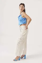 Pantalón de jean plateado con efecto metalizado, corte wide leg y bolsillos cargo.