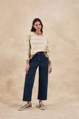 Sweater de punto color beige melange con rayas horizontales en tono dorado brillante. Presenta cuello redondo y puños y ruedo en color marrón.