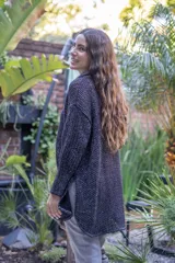 Camisa tejida en punto calado color marrón con hilo de algodón y lurex. Silueta oversize, mangas 3/4 ligeramente abullonadas, cuello camisero clásico y botonadura frontal con botones metálicos dorados.