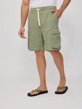 Short color verde militar, con bolsillos cargo laterales, cintura elastizada con cordón ajustable.