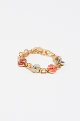 Pulsera de cadena de eslabones dorados con dijes circulares esmaltados en colores rojo, celeste, rosado y azul marino con inscripciones de marca. Incluye cierre de mosquetón y un pequeño dije de corazón dorado.