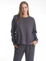 Buzo deportivo de cuello redondo, con hombros caídos y mangas largas con puños. Presenta costuras decorativas tipo pespunte en la parte frontal y en las mangas, con un diseño de ruedo recto y tajos laterales.